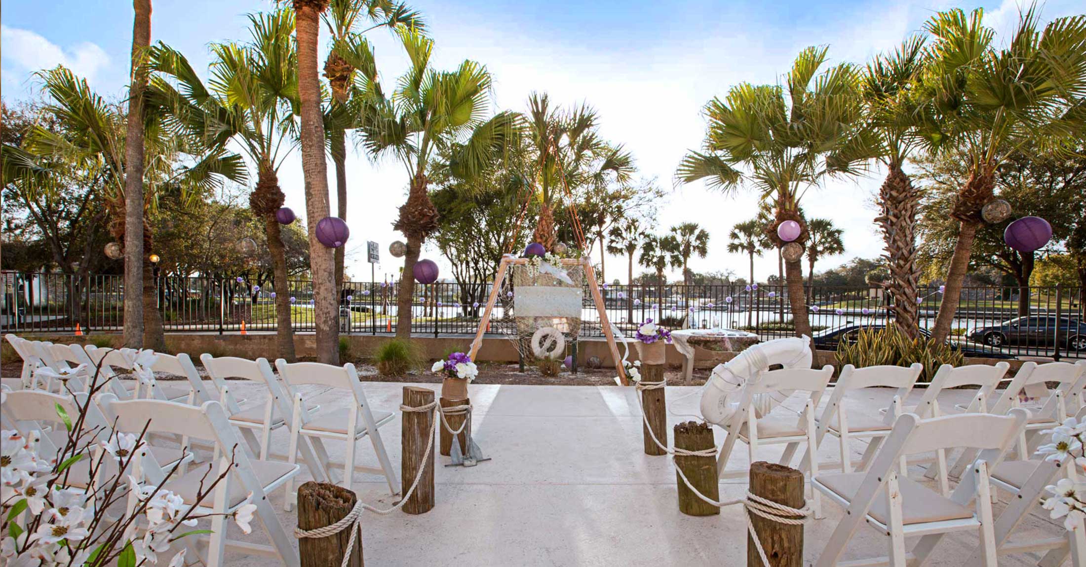 wedding ceremony setup on outdoor pool deck facing riverwalk and river