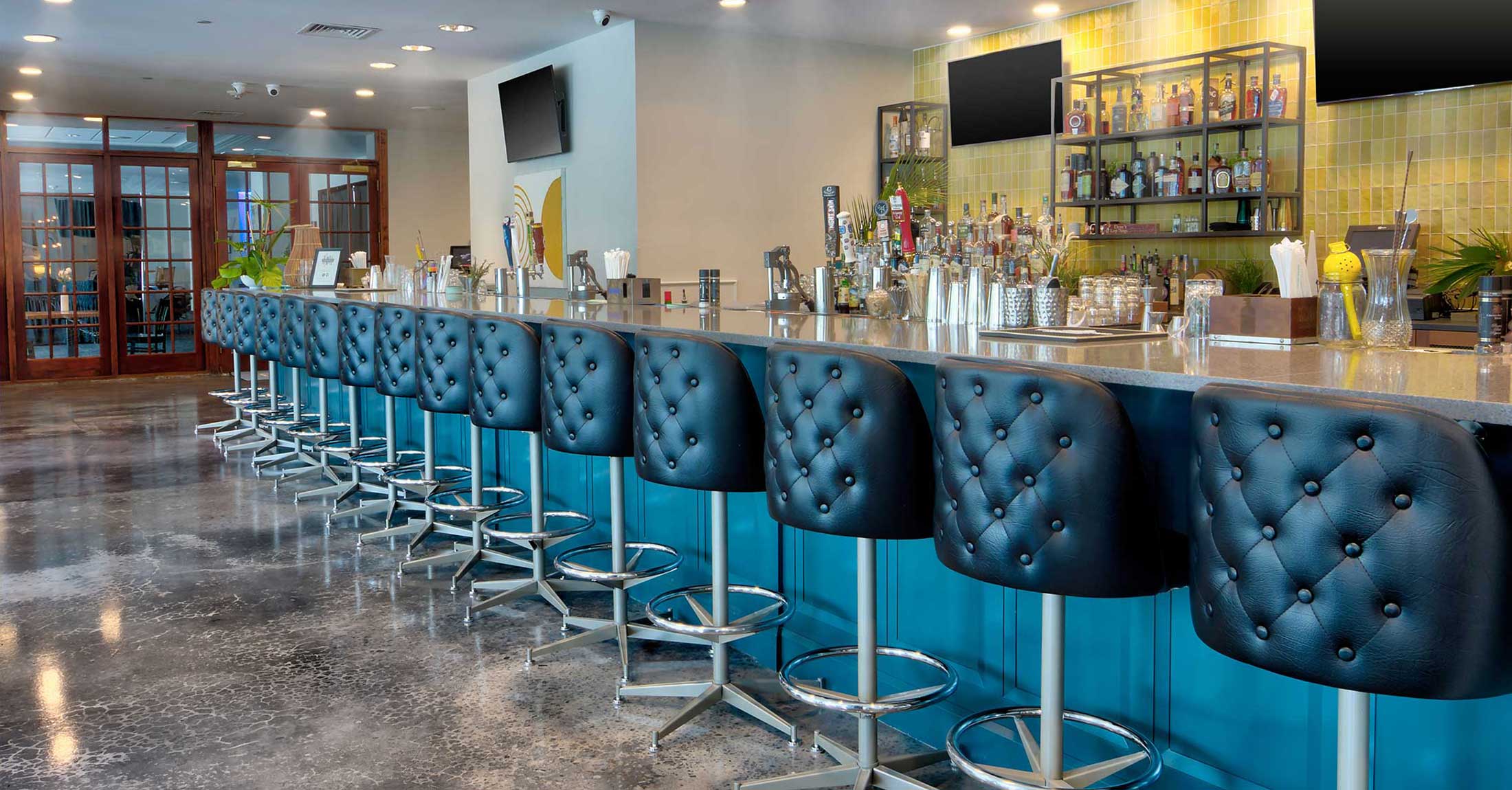 alternate view of long main bar with black cushioned bar stools