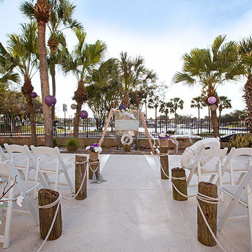 view of poolside wedding seating and arbor facing river